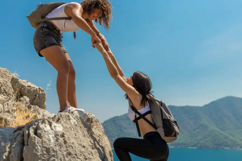 Woman hiker helping another hiker